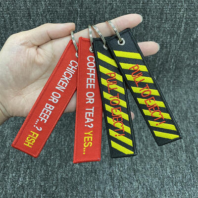 kupować Niestandardowe logo Broderia List Logo Tag kluczowy Usuń broderowany samolot przed lotem Znaczniki Łańcuchy kluczowe z wzorem lalki online manufacture